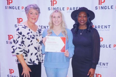 Karmen holds her scholarship certificate between two ASPSF volunteers
