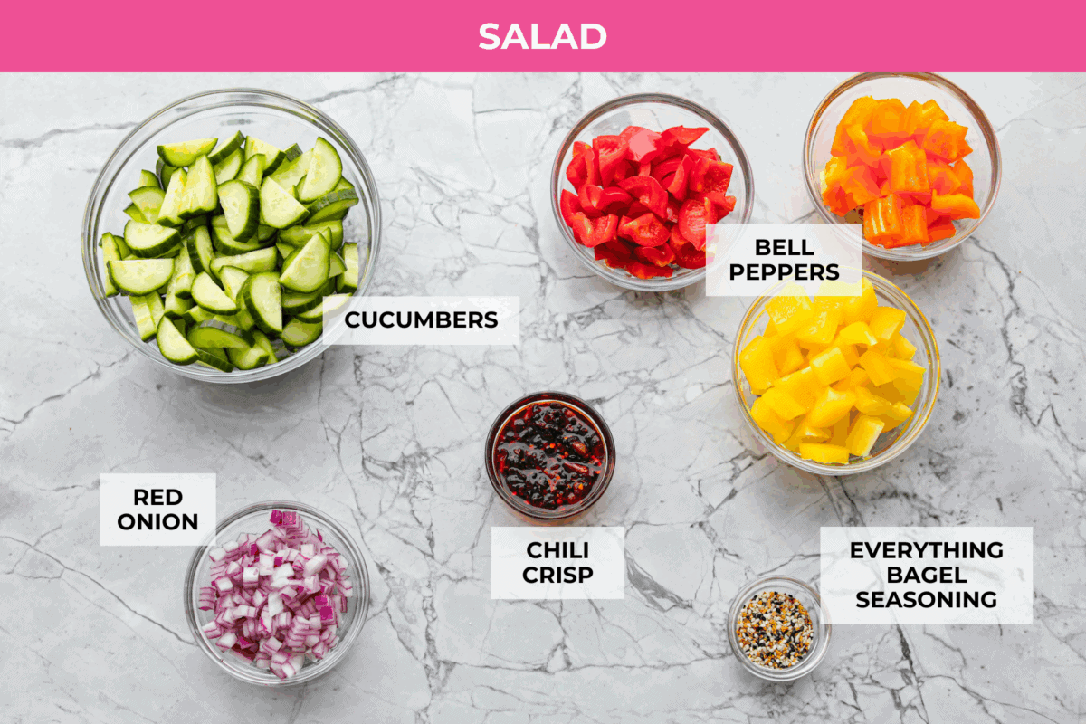 I don’t know what kind of hold cucumbers have on me lately, but I’m obsessed. This cucumber bell pepper salad is crunchy, a little sweet, a little spicy, and totally guilt-free. Overhead shot of labeled cucumber and bell pepper salad ingredients.