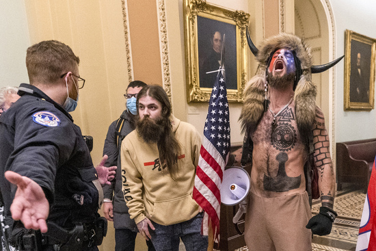 FILE - In this Jan. 6, 2021 file photo, supporters of President Donald Trump, including Jacob Chansley, right with fur hat, are confronted by U.S. Capitol Police officers outside the Senate Chamber inside the Capitol in Washington. Many of those who stormed the Capitol on Jan. 6 cited falsehoods about the election, and now some of them are hoping their gullibility helps them in court. Albert Watkins, the St. Louis attorney representing Chansley, the so-called QAnon shaman, likened the process to brainwashing, or falling into the clutches of a cult. Repeated exposure to falsehood and incendiary rhetoric, Watkins said, ultimately overwhelmed his client's ability to discern reality. (AP Photo/Manuel Balce Ceneta, File) FILE - In this Jan. 6, 2021 file photo, supporters of President Donald Trump, including Jacob Chansley, right with fur hat, are confronted by U.S. Capitol Police officers outside the Senate Chamber inside the Capitol in Washington. Many of those who stormed the Capitol on Jan. 6 cited falsehoods about the election, and now some of them are hoping their gullibility helps them in court. Albert Watkins, the St. Louis attorney representing Chansley, the so-called QAnon shaman, likened the process to brainwashing, or falling into the clutches of a cult. Repeated exposure to falsehood and incendiary rhetoric, Watkins said, ultimately overwhelmed his client's ability to discern reality. (AP Photo/Manuel Balce Ceneta, File)