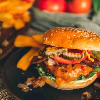 Smoked burger on a plate with fries.