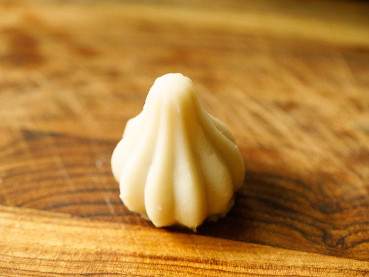 modak shaped with the modak mould placed on wooden board. 